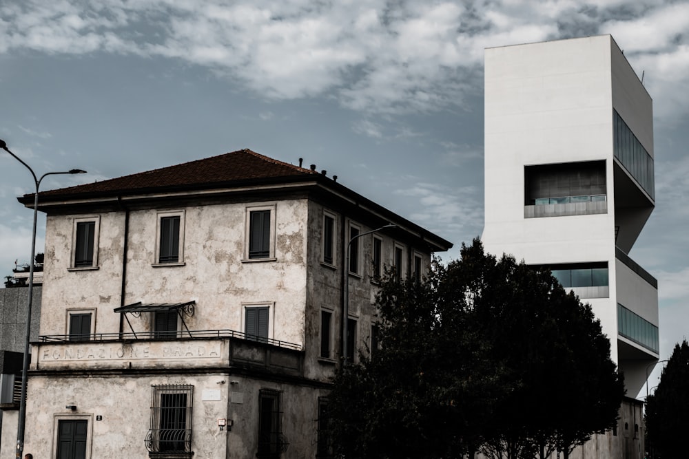 white concrete building near green trees under blue sky during daytime