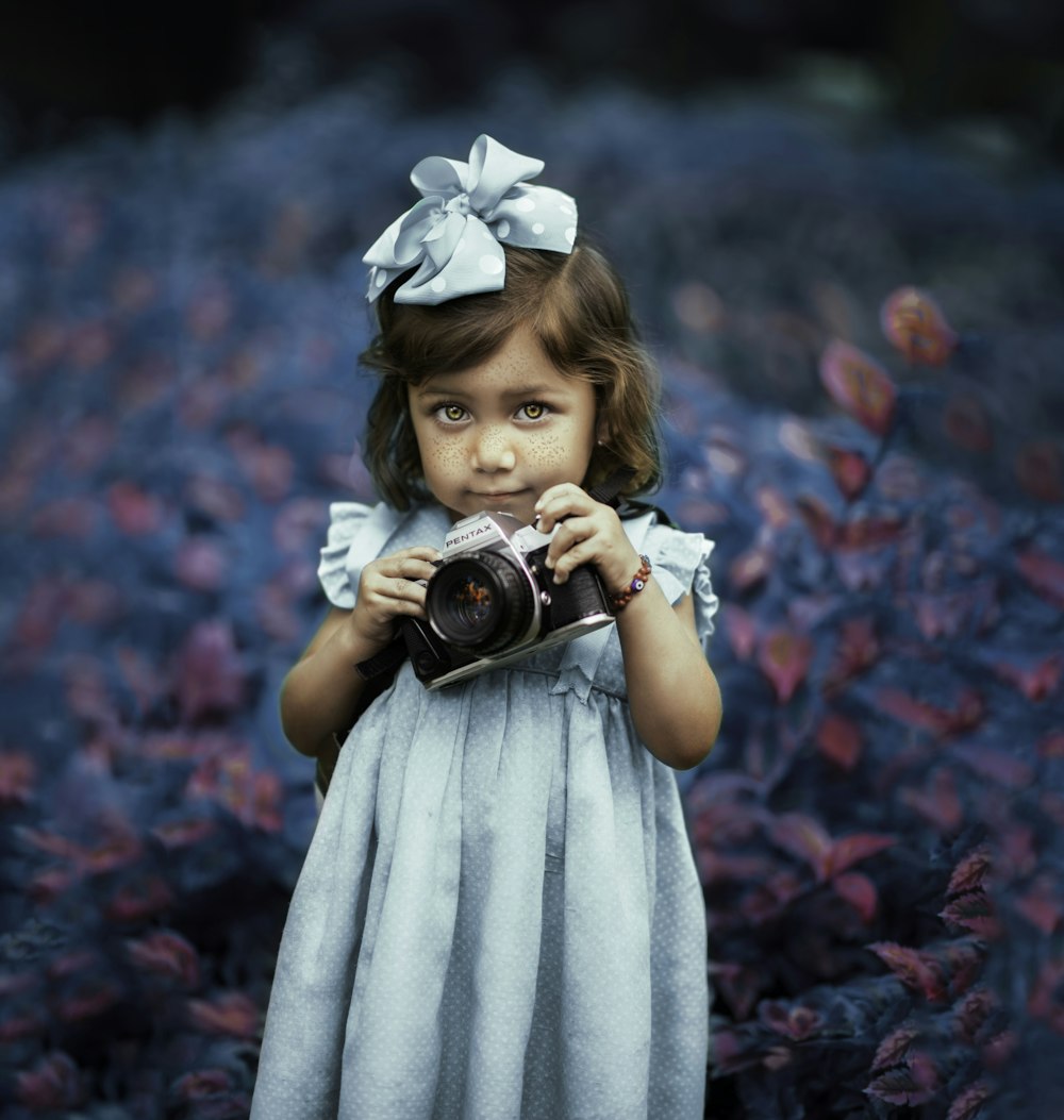 girl in white dress holding black dslr camera