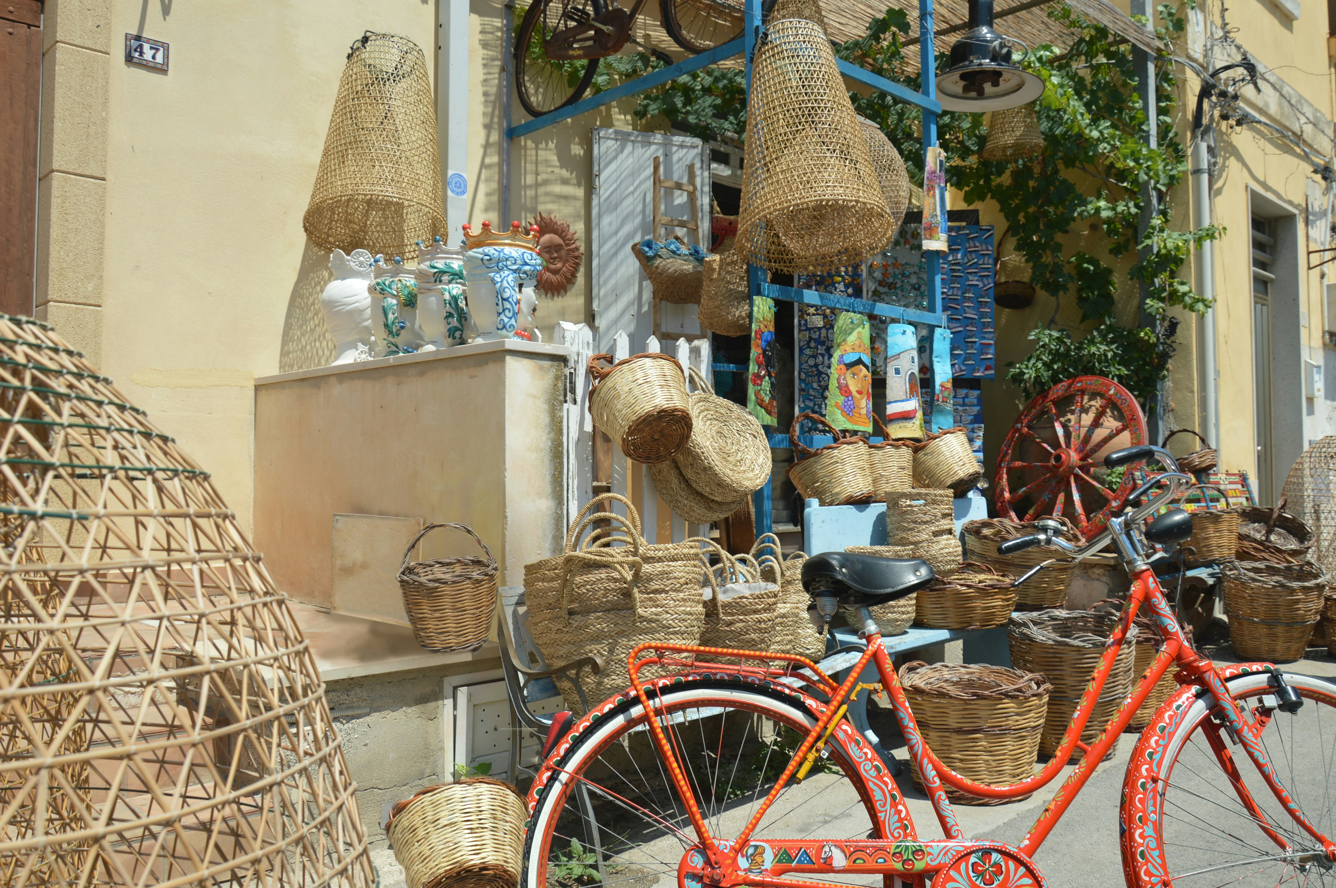 red bicycle parked beside brown wicker basket