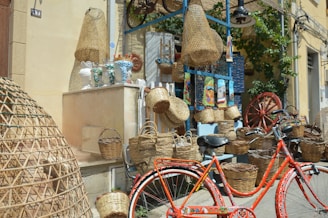 red bicycle parked beside brown wicker basket