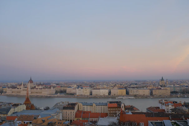 A panoramic view of the Parliament Hill in Ottawa, captured at sunset with warm light highlighting the architecture.