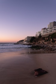 A cinematic shot of a beachfront resort at dusk, with vibrant colors and gentle waves creating a peaceful mood.