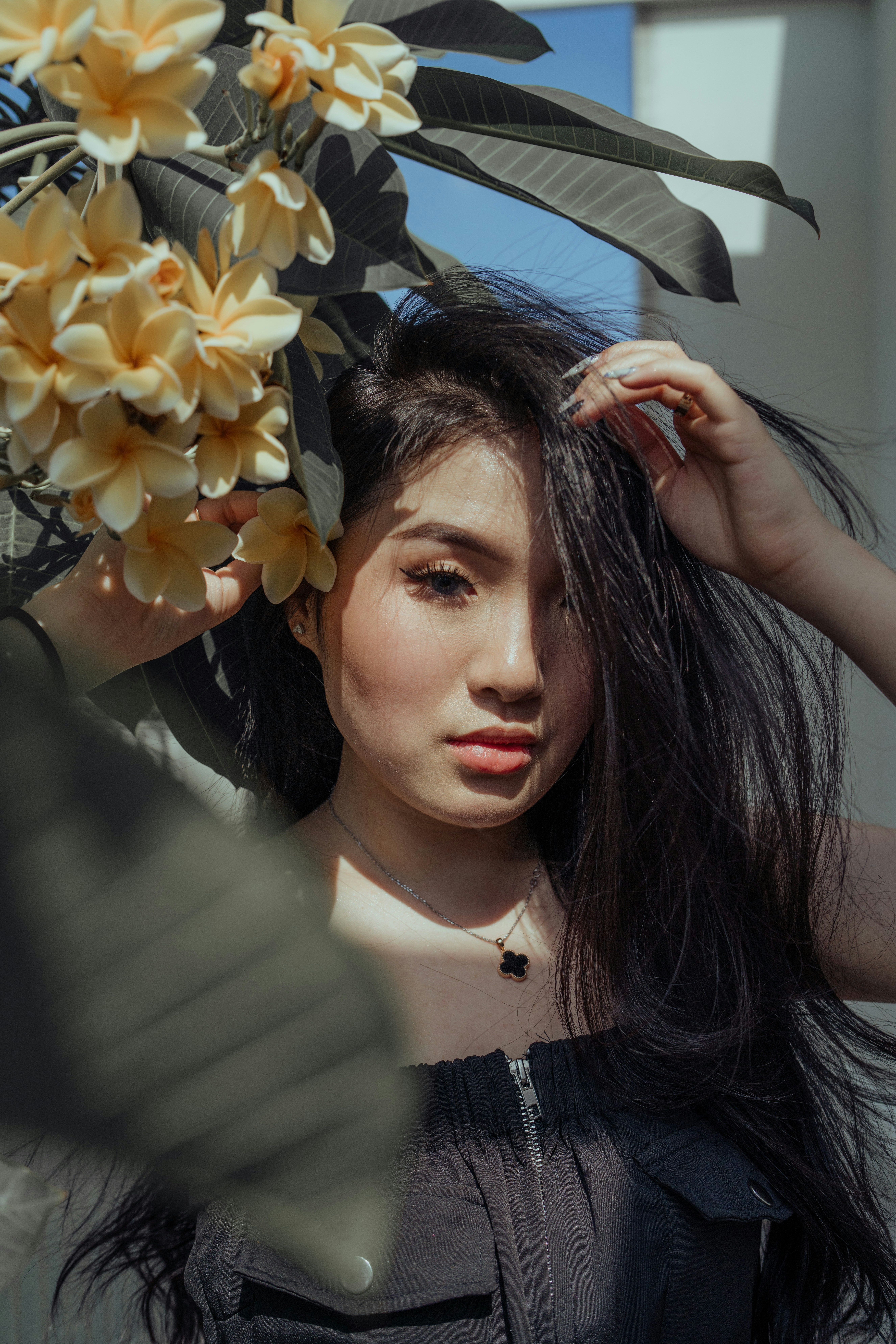 Femme en chemise rayée blanche et noire tenant des fleurs jaunes