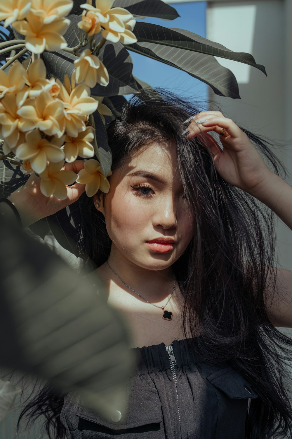 woman in white and black striped shirt holding yellow flowers