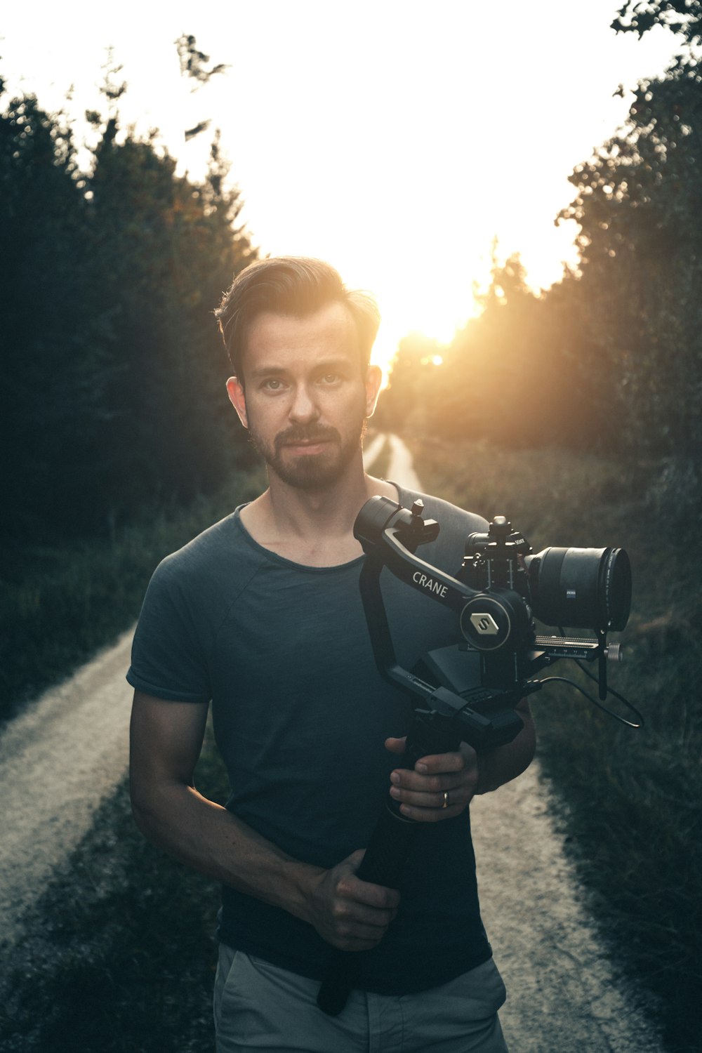 man in blue crew neck t-shirt holding black dslr camera