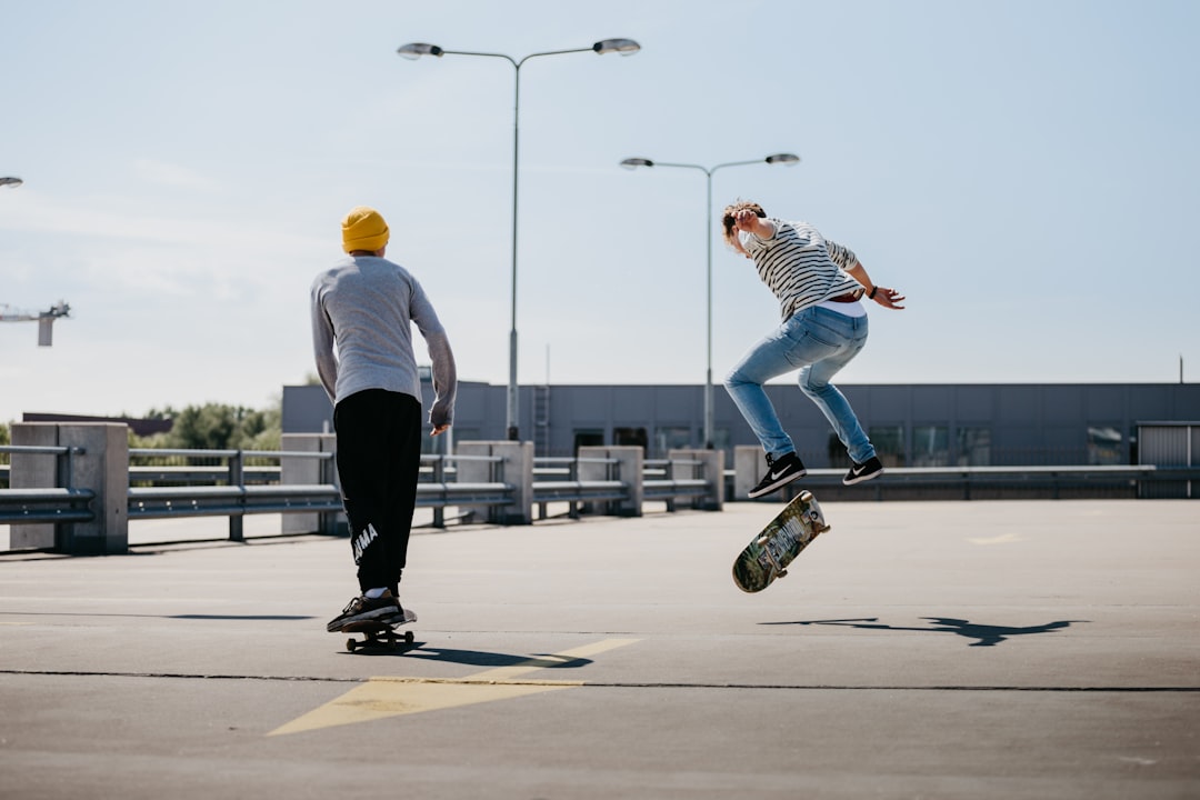 man in white shirt and black pants playing skateboard during daytime