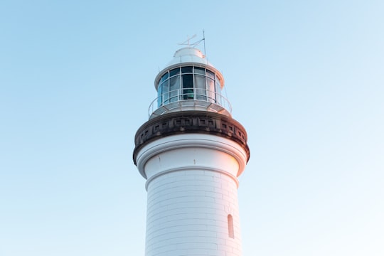 white and brown concrete lighthouse under blue sky during daytime in Cape Byron Lighthouse Australia