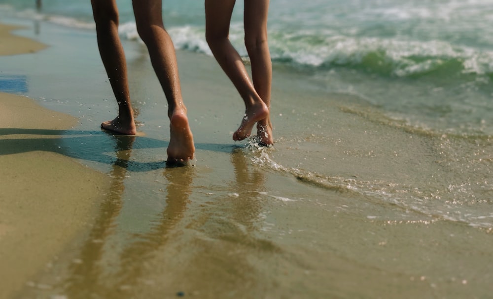 3 women standing on beach during daytime