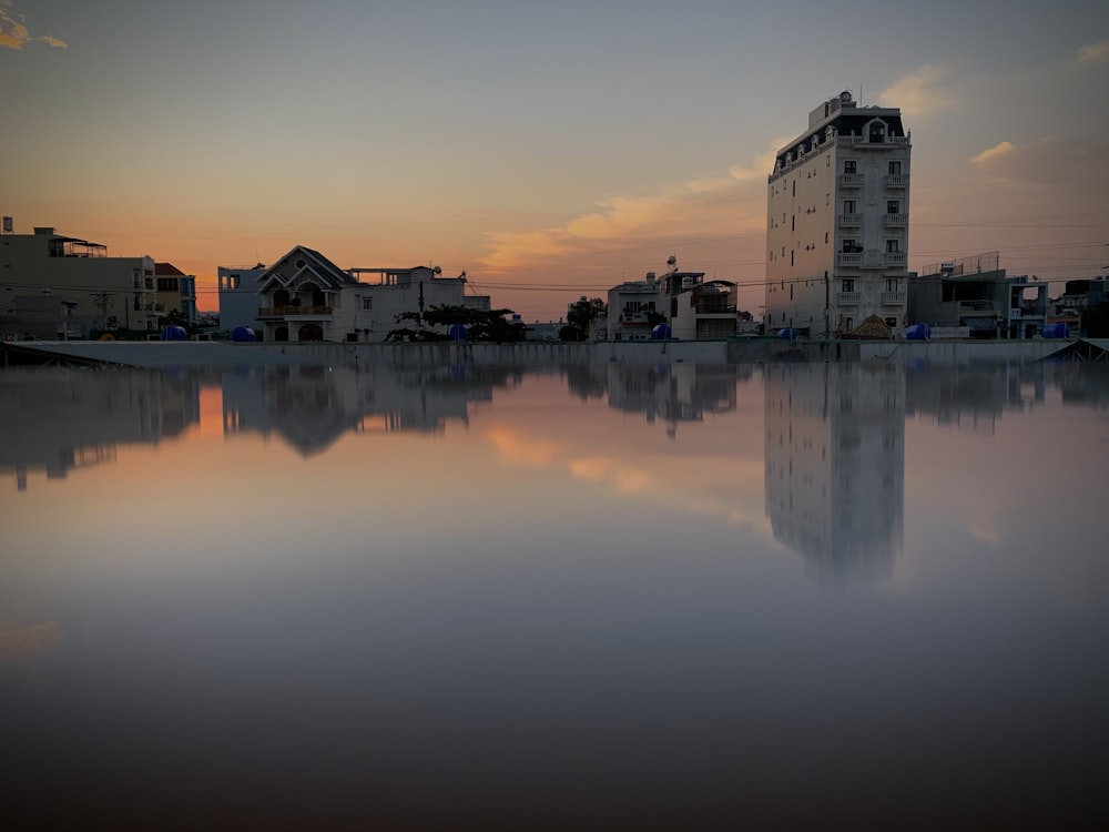 white concrete building near body of water during sunset