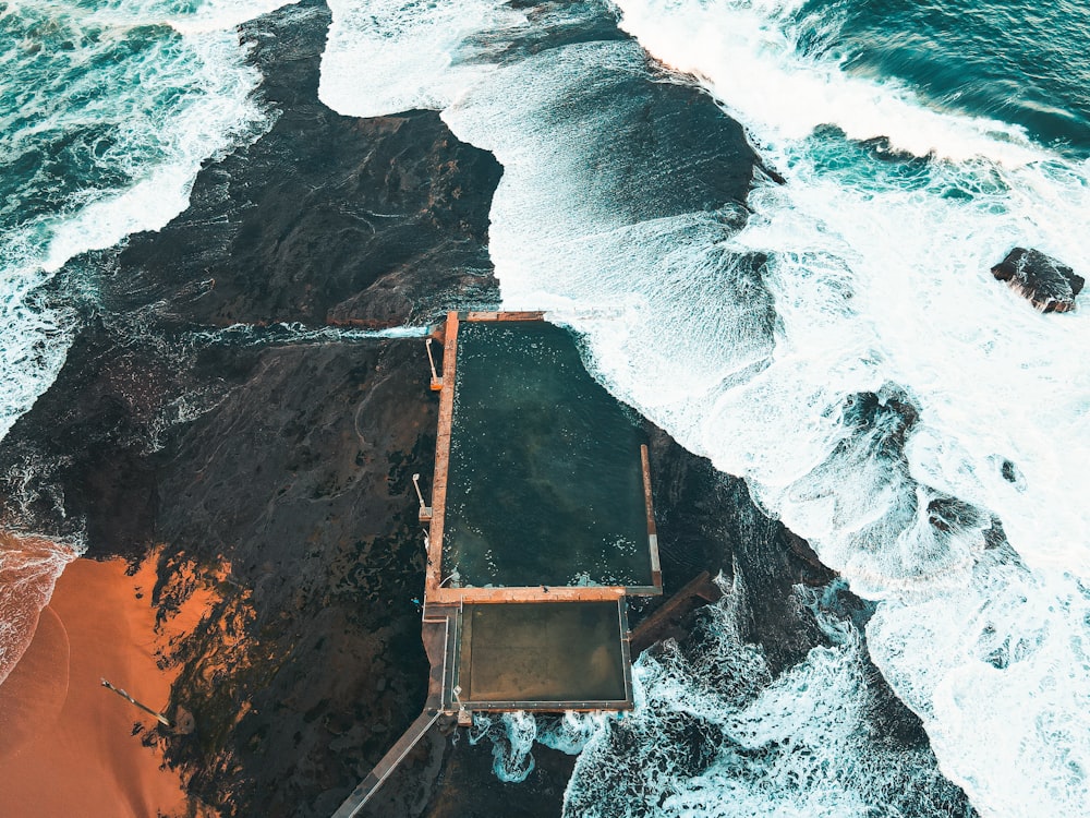 brown wooden ladder on rocky shore during daytime