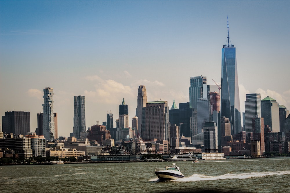 white boat on water near city buildings during daytime