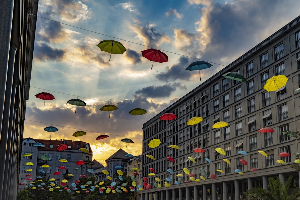 people walking on street with umbrella and cars parked on the side during daytime