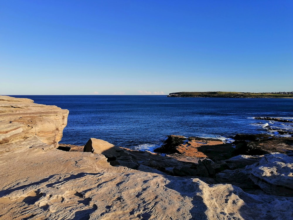 brown rock formation near body of water during daytime