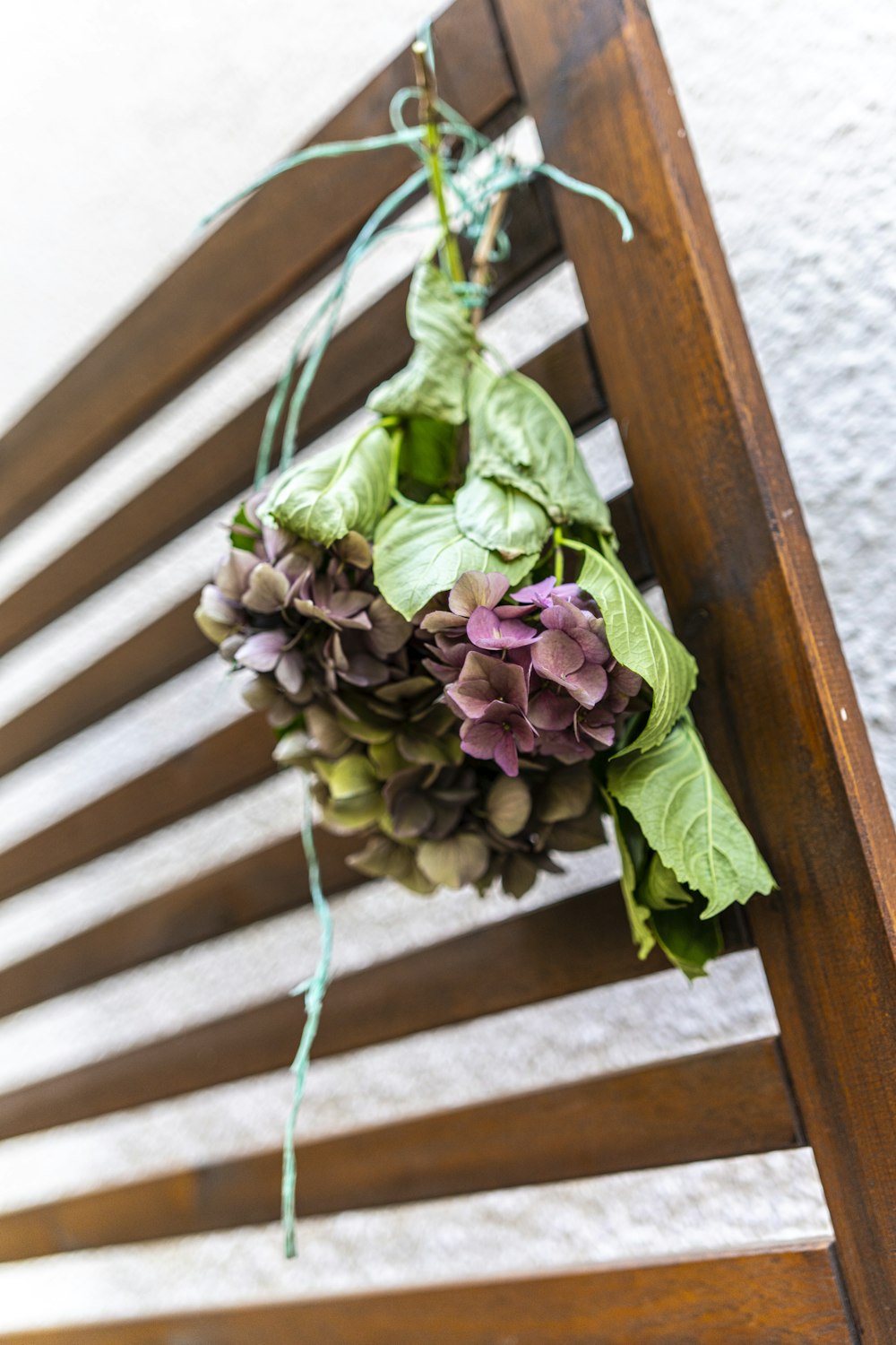 green and purple flower bouquet on brown wooden staircase