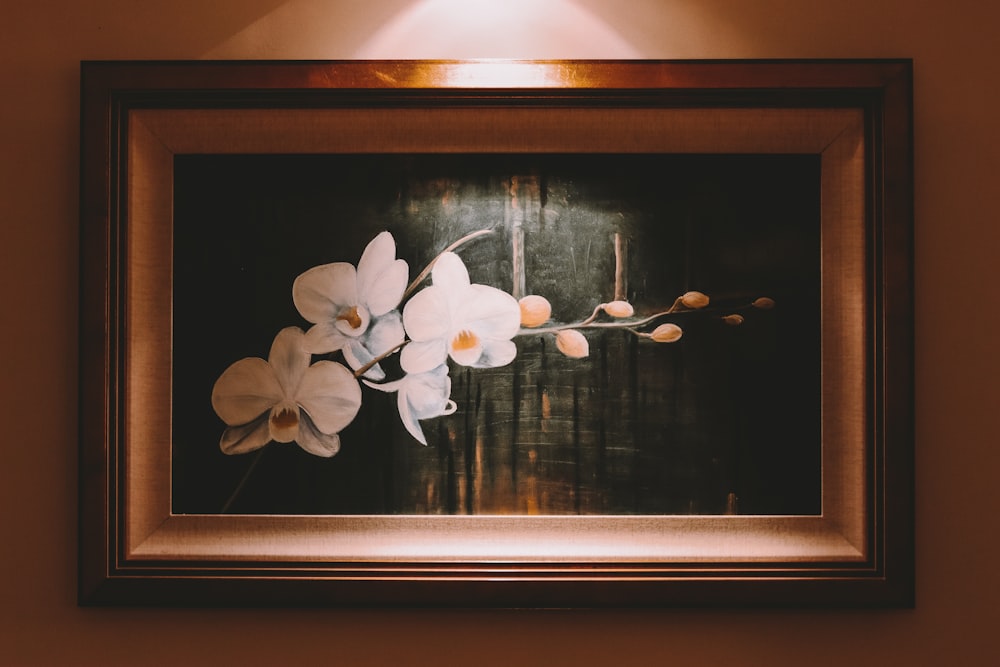 white flower painting with brown wooden frame