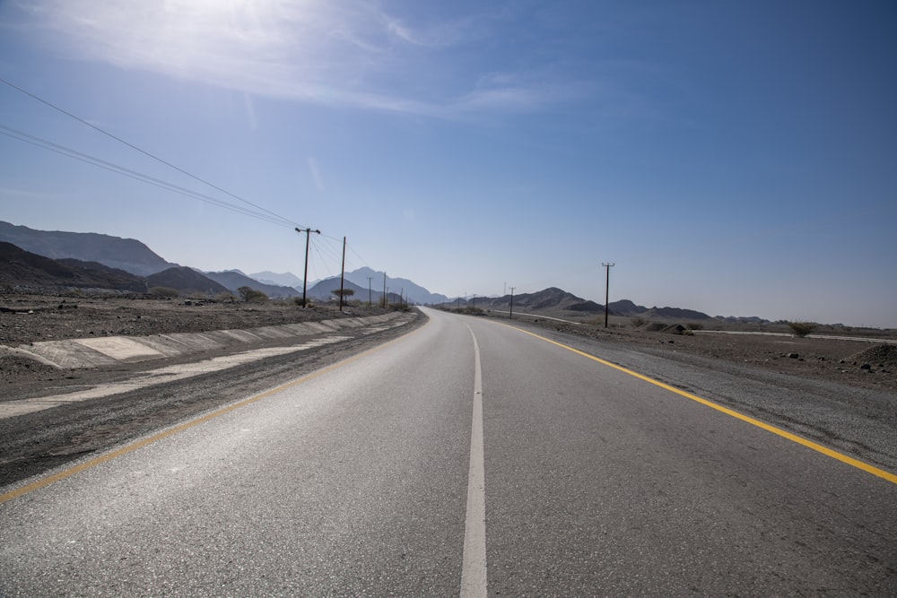 gray concrete road under blue sky during daytime