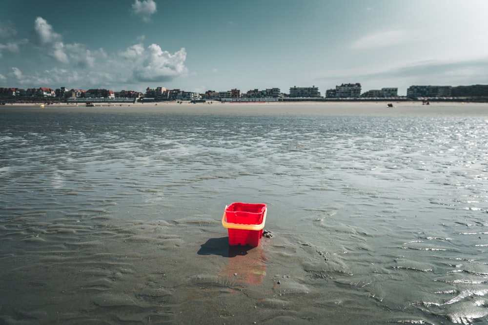 red plastic bucket on water