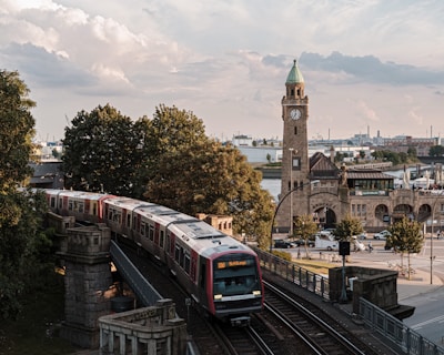 brown and white train on rail road near brown concrete building during daytime