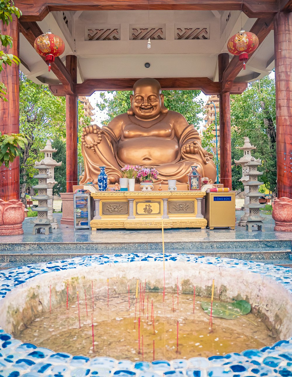 gold buddha statue under white roof during daytime