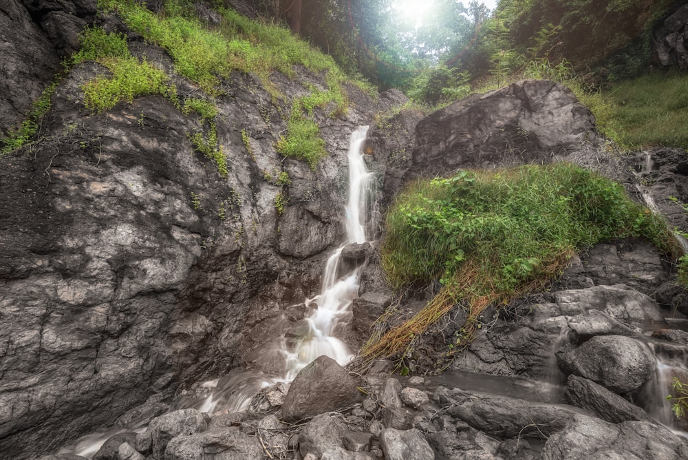water falls between gray rocks