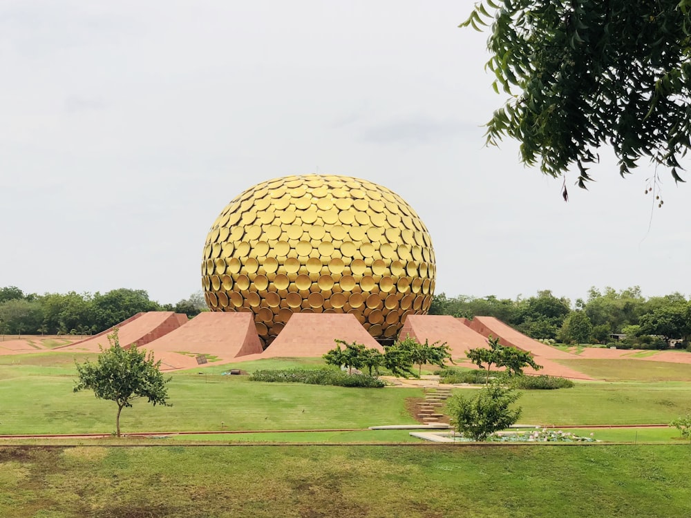 Costruzione della cupola marrone sul campo di erba verde durante il giorno