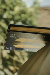 Moody photo of a minimalist black and gold e-book cover lit by warm golden light trails.