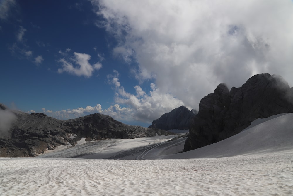 snow covered mountain under white clouds and blue sky during daytime