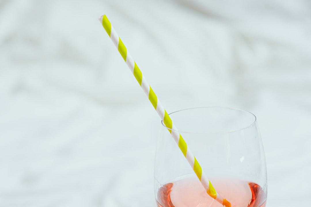 clear drinking glass with white and yellow straw