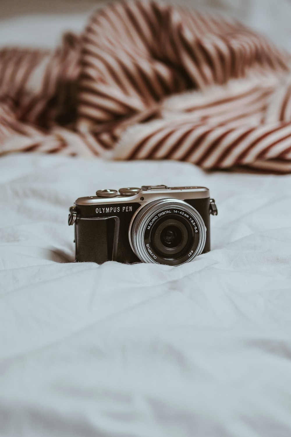 black and silver camera on white textile