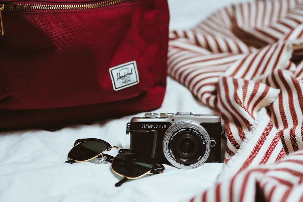 black and silver nikon camera on white and red striped textile