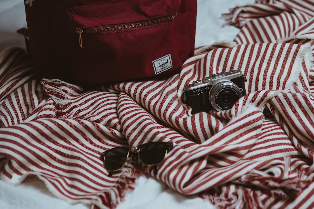 Appareil photo reflex numérique Canon noir et argent sur textile rouge et blanc