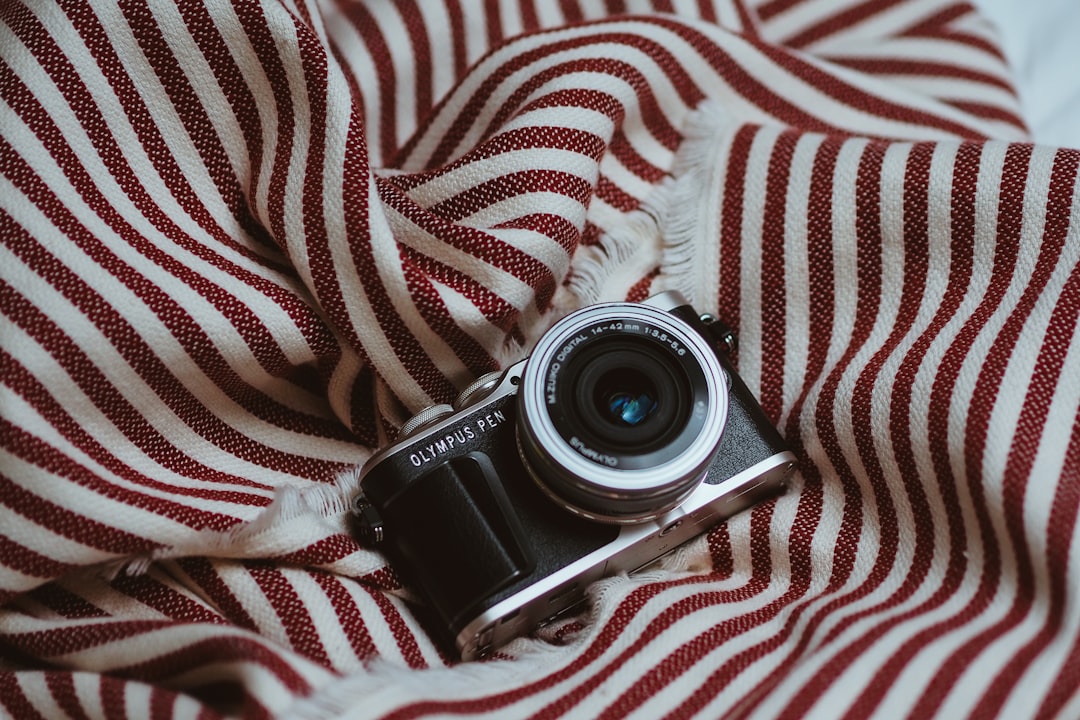 black nikon dslr camera on white and red textile