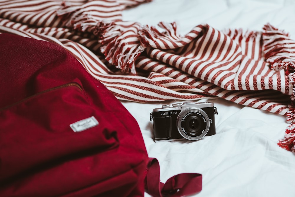 black and silver camera on white and red textile