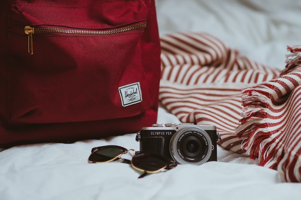 black and silver dslr camera on white textile