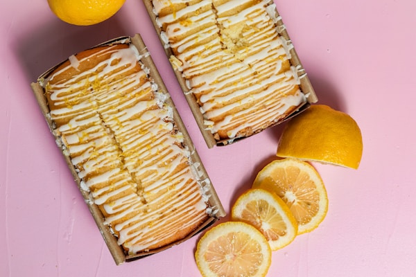A light lemon drizzle cake with a glossy citrus glaze and candied lemon slices on top.