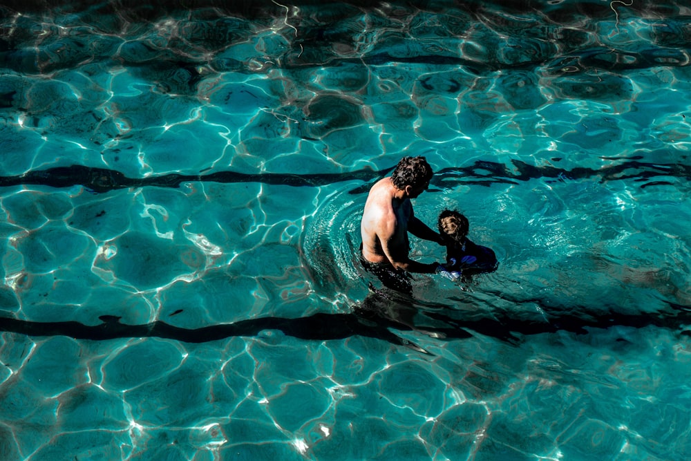 man in blue shorts swimming in water