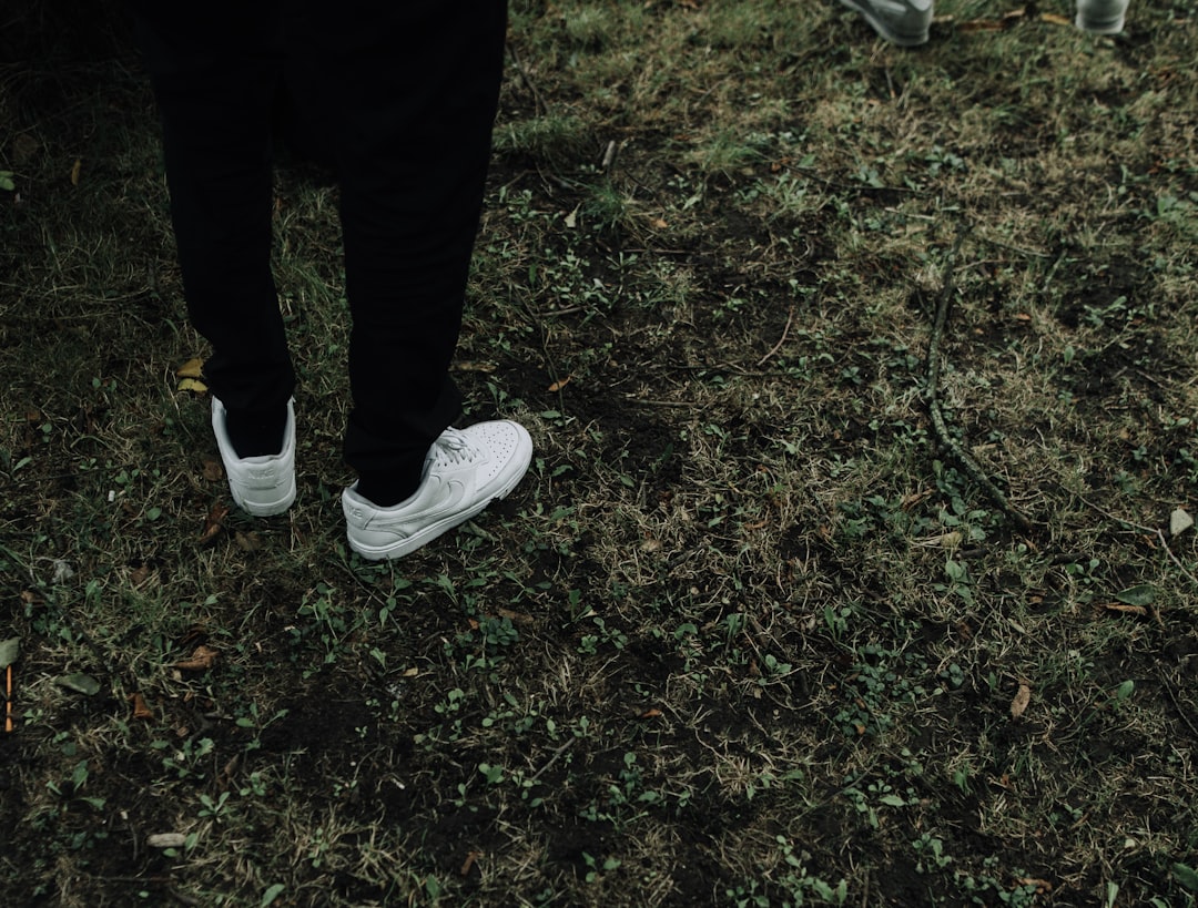 person in black pants and white sneakers