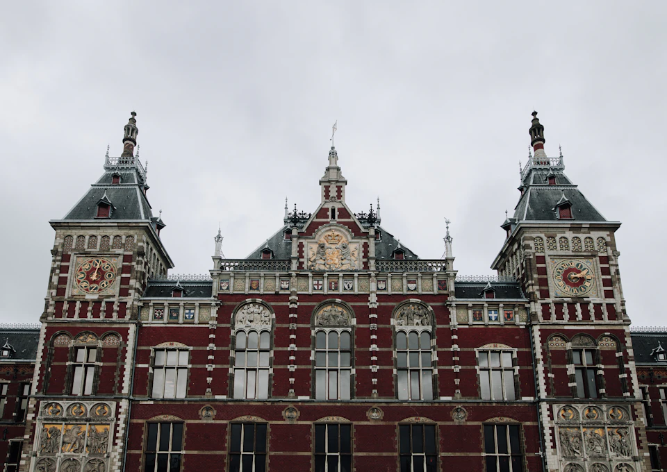 Large ornate red brick building with towers and clock tower dominates the landscape