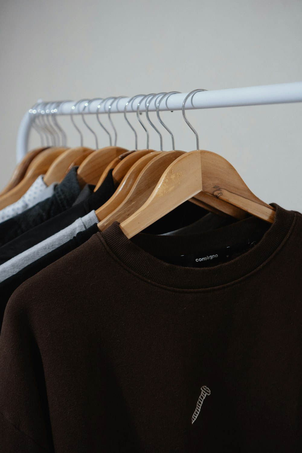 black crew neck shirt on white plastic clothes hanger