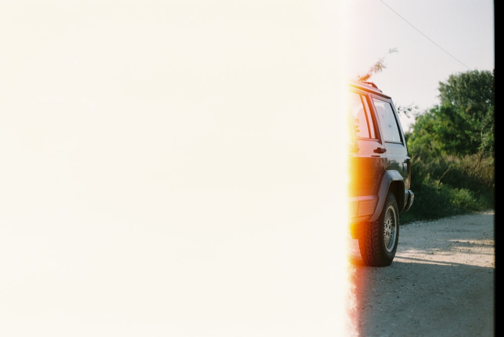 orange suv on gray asphalt road during daytime