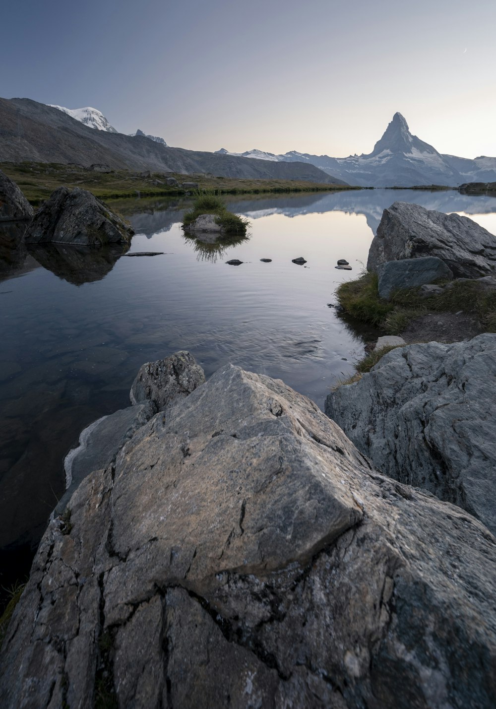 formazione rocciosa grigia accanto allo specchio d'acqua durante il giorno