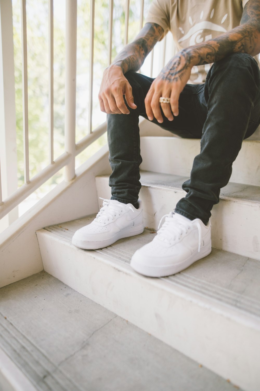 person in black pants and white nike sneakers sitting on white concrete  stairs photo – Free Grey Image on Unsplash