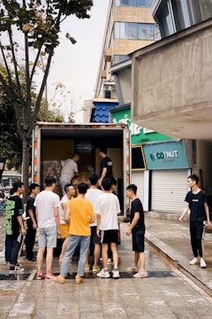 Team of workers loading furniture into a moving truck in an urban setting.
