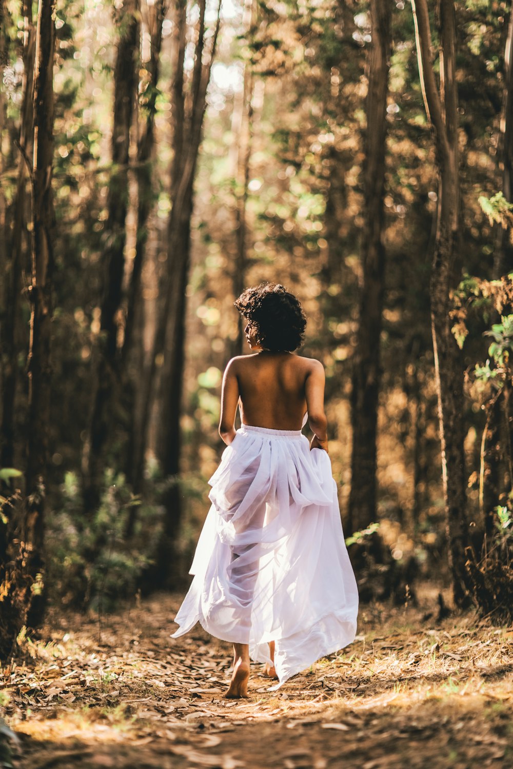 woman in white tube dress standing on brown grass field during daytime