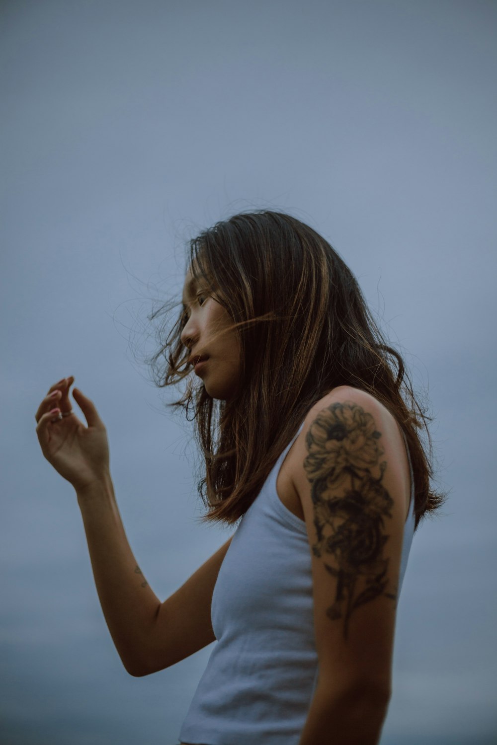 woman in white tank top with black tattoo on her left hand