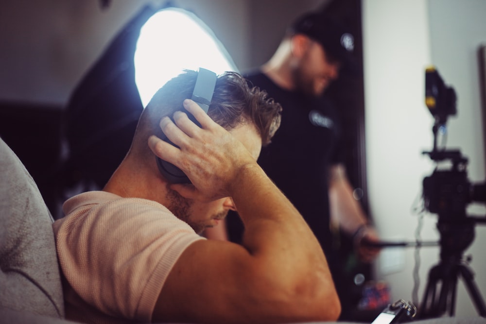 man in white t-shirt covering his face