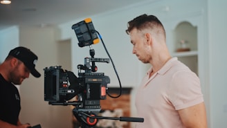man in white dress shirt holding black video camera