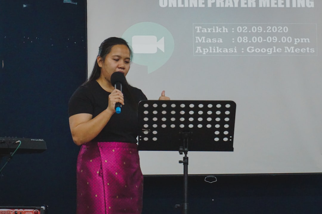 woman in black crew neck t-shirt and pink pants singing, Women Empowerment; hosting a sunday service