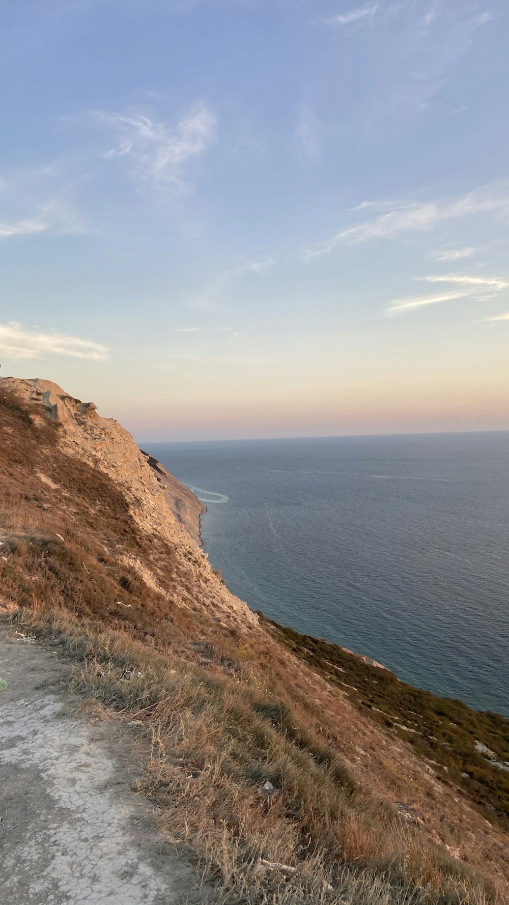 brown rock formation beside blue sea under blue sky during daytime