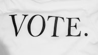 Bold black lettering spells out the word 'VOTE.' on a plain white background. The typography is simple and clear, conveying a direct message.